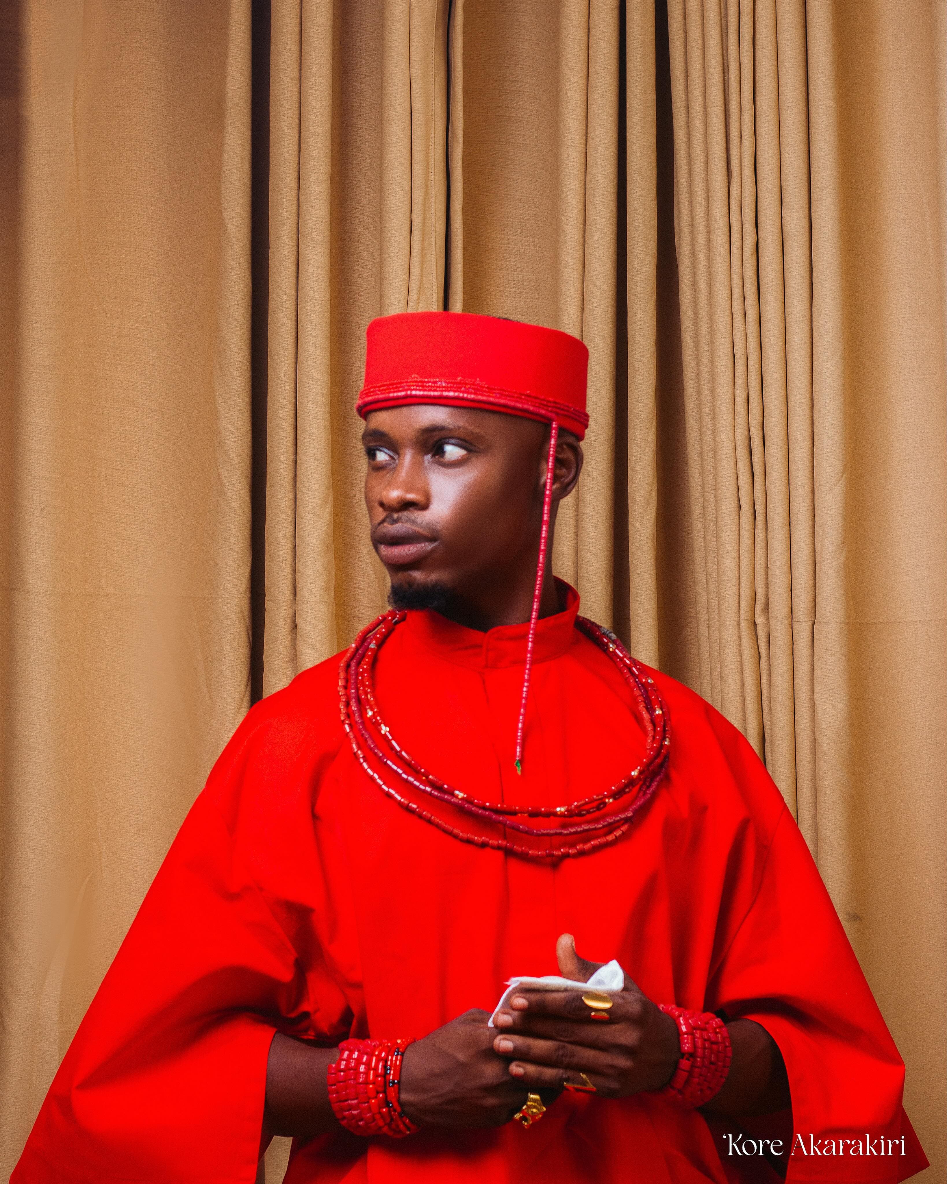 Man in traditional red attire, photographed by Kore Akarakiri